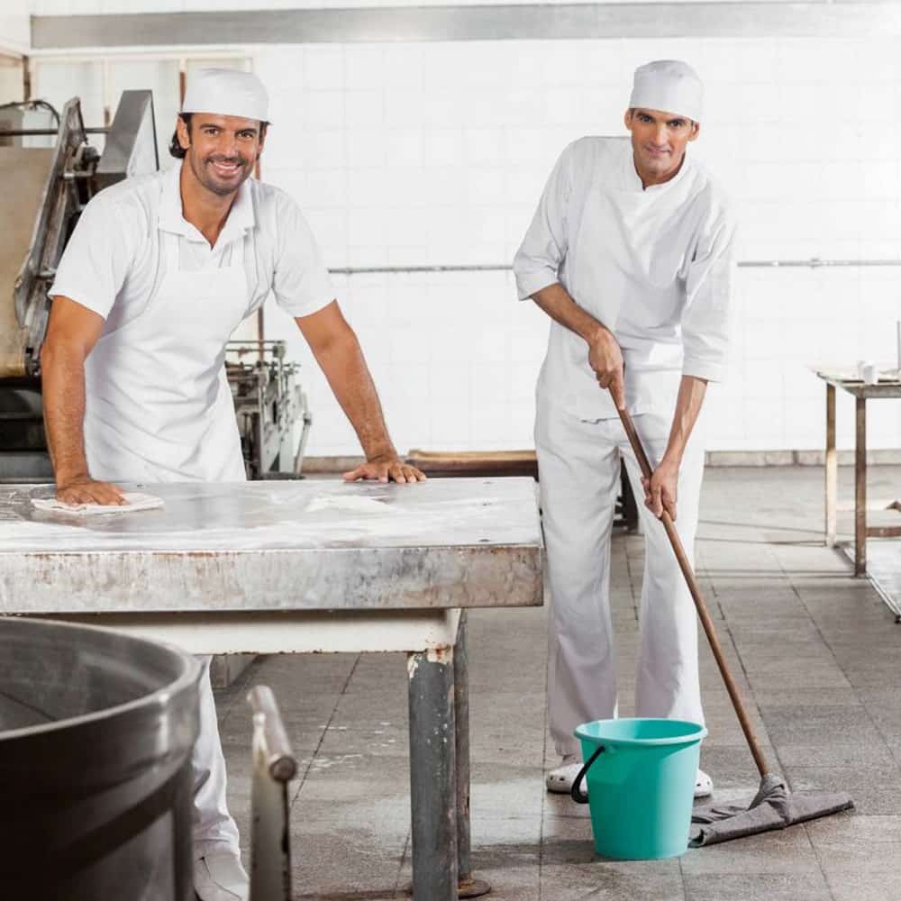 To mandlige køkkenassistenter , der gør rent.
