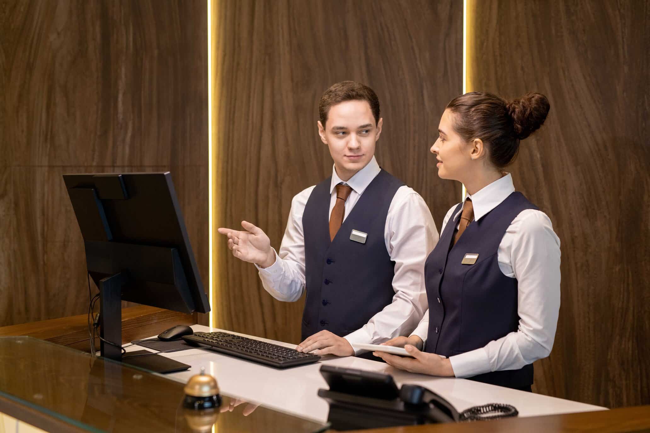 En mandelig og kvindelig receptionister der taler sammen i en hotelreception